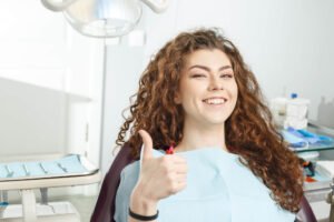 a woman giving a thumbs up sign after receiving El Dorado Hills Cosmetic Dentistry